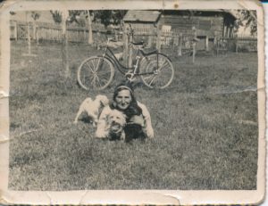 Sarenka ze swoimi pieskami i rowerem. Zdjęcie ze zbiorów Niny Ławryszowej.